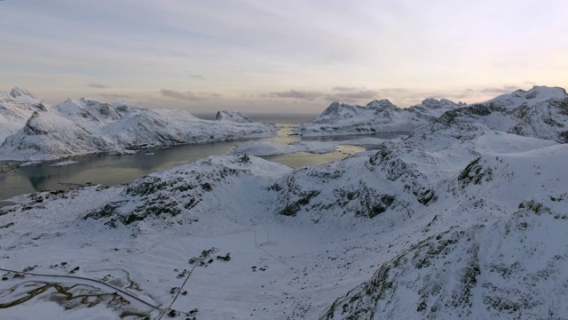 空中向前盘从右到左缓慢:雪覆盖地区的小房子-罗浮敦，挪威视频素材