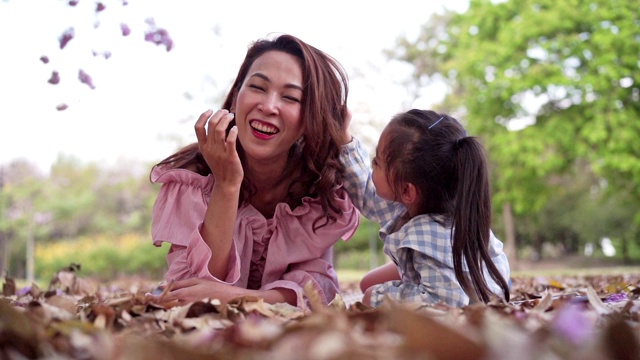 母亲和女儿在花园里读童话。每周的假期。视频素材