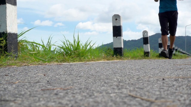 强壮的亚洲男性在户外的道路上奔跑。视频素材