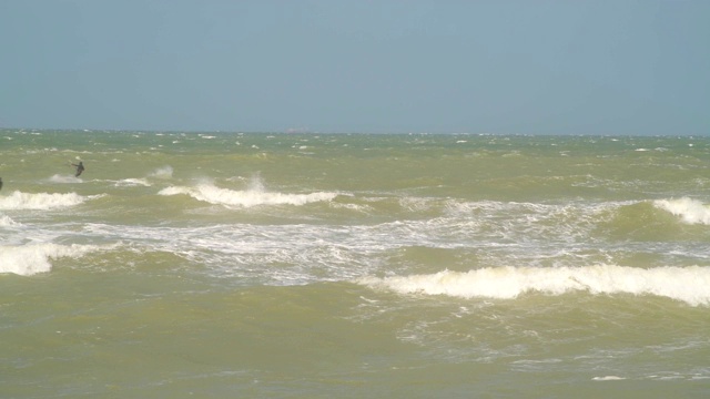 风筝冲浪者和冲浪者在海上经过视频素材