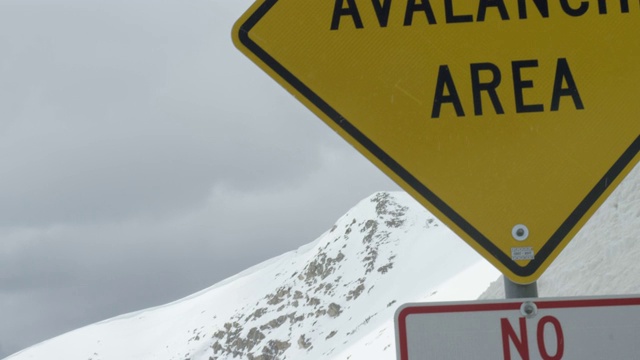 “雪崩地区”警告路标在科罗拉多州的落基山脉下阴天在冬天视频素材