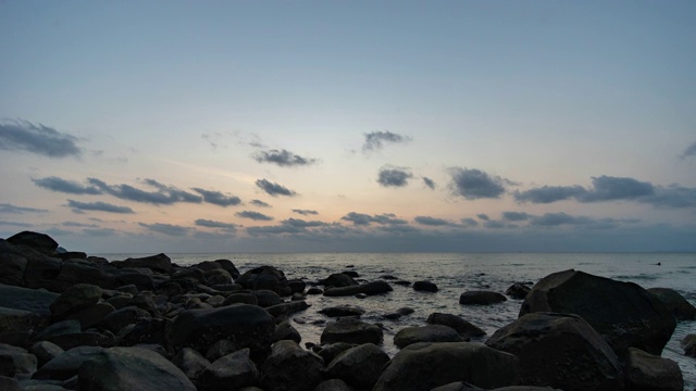 海洋和海滩与岩石在日落，时间流逝视频视频素材