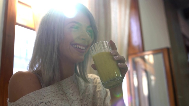 美丽的年轻女子喝着冰沙微笑着视频素材