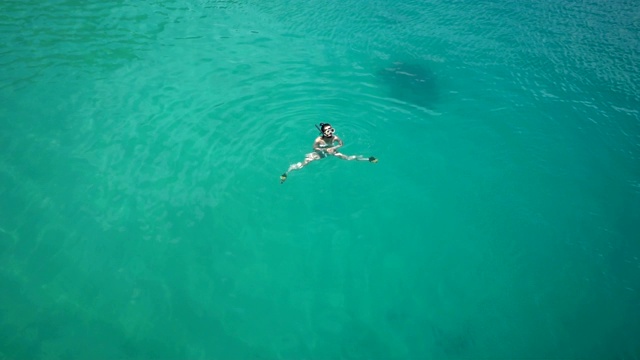 空中俯瞰女人浮潜从上面，女孩浮潜游泳在清澈的热带海水与珊瑚在泰国暑假期间视频素材