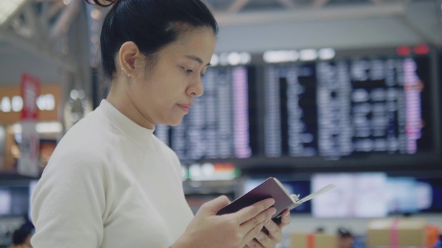 亚洲女游客在机场登机板上检查和查看航班视频素材