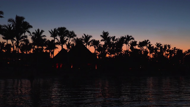 异国情调的海滩和夕阳。浪漫的夜晚，海面上灯火通明视频素材