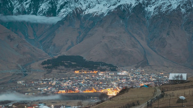 Stepantsminda,格鲁吉亚。乡村景观在晚上的时间在山的背景Kazbegi区，格鲁吉亚。秋天的村庄之路视频素材