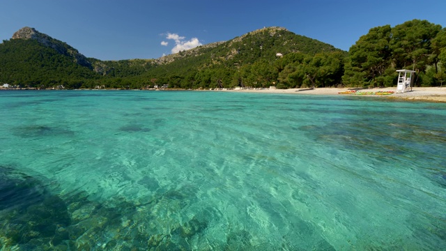 西班牙马略卡岛美丽的大海和海滩。在阳光明媚的日子里，地中海清澈透明的绿松石水在风中摇摆。4 k视频素材