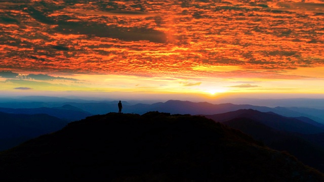 在夕阳的衬托下，那人在山上剪影视频素材