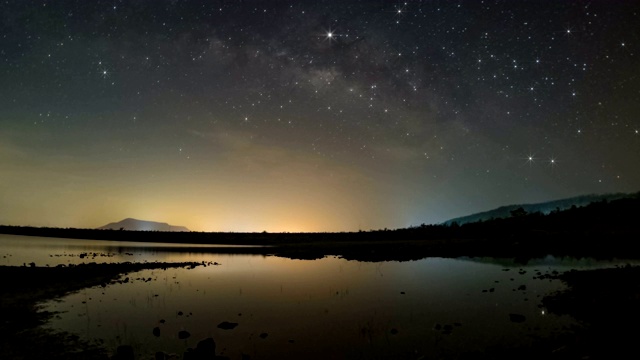 晚上，天上的星星反射光线。银河之上的山脉和池塘湄普拉昌大坝和水库，碧府，泰国视频素材