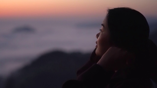 年轻女子看着山上的风景与阳光和雾。带着相机独自旅行的背包客。假日旅游和度假概念。视频素材