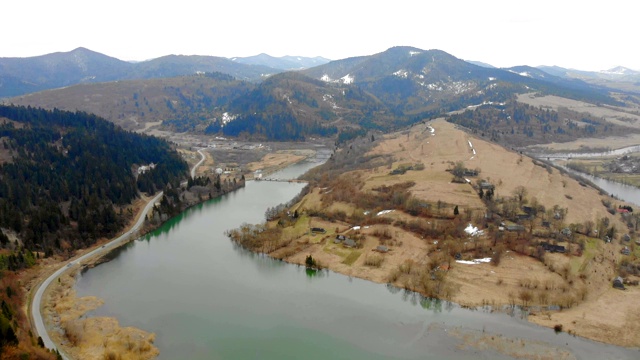 在多云天气下从山上的湖上取下无人机。美丽的秋天风景与森林和山脉。视频素材