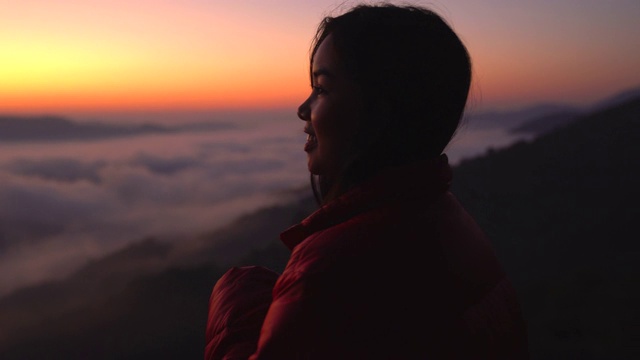 年轻女子看着山上的风景与阳光和雾。带着相机独自旅行的背包客。假日旅游和度假概念。视频素材