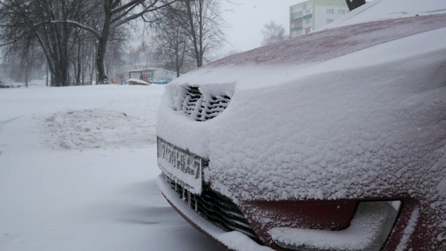 汽车被雪覆盖，在严冬的暴风雪中。视频素材