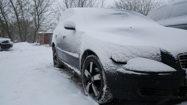 汽车被雪覆盖，在严冬的暴风雪中。视频素材