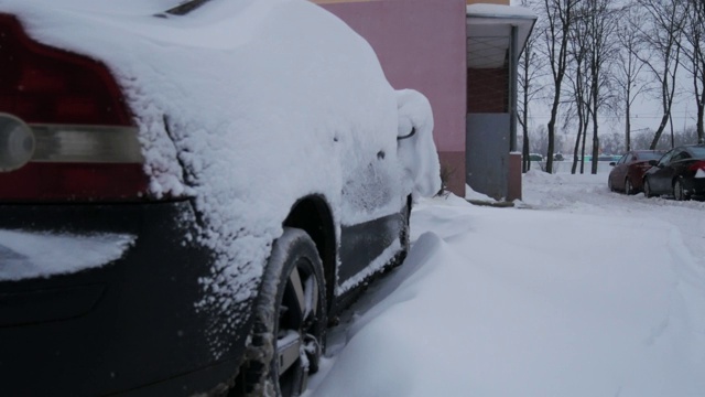 汽车被雪覆盖，在严冬的暴风雪中。视频素材