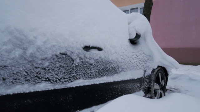 汽车被雪覆盖，在严冬的暴风雪中。视频素材