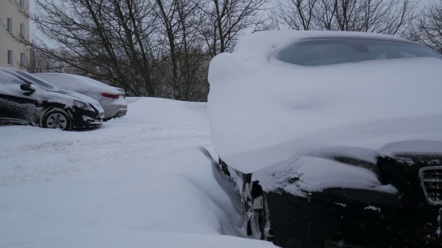 汽车被雪覆盖，在严冬的暴风雪中。视频素材