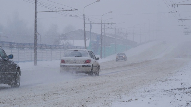 城市遭遇暴风雪天气。交通在城市中行驶，在暴风雪期间。视频素材