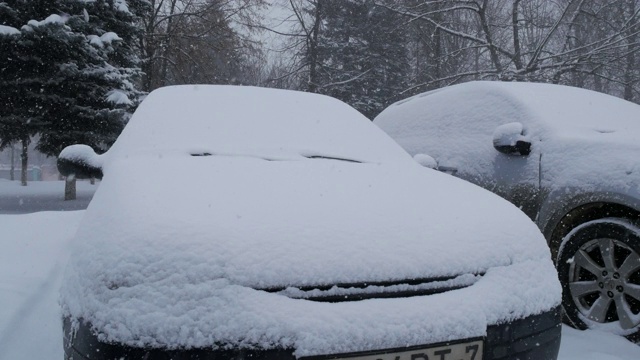 汽车被雪覆盖，在严冬的暴风雪中。视频素材