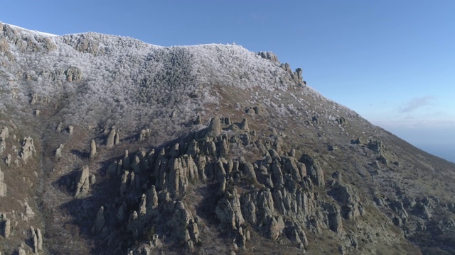 山顶上的景色覆盖着巨大的岩石和雪白的灌木，映衬着湛蓝清澈的天空。鸟瞰图视频素材