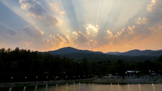 云和阳光的时间流逝，山和水库在傍晚。视频素材