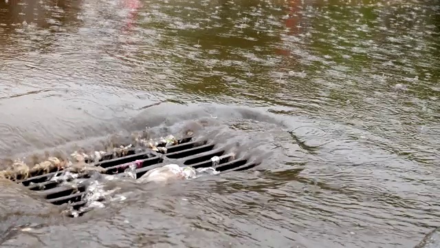 雨水在城市的暴雨排水沟中流动。视频素材