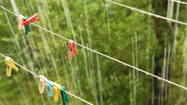 大雨下挂着带彩色别针的晾衣绳视频素材