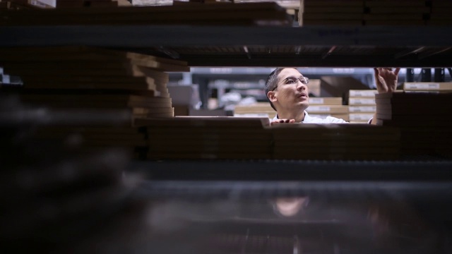 男人在建筑车间选购材料。亚洲男设计师在五金店购物视频素材