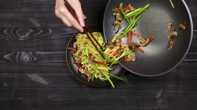 用炒锅把蒜芽、蘑菇片和鸡肉放在盘子里翻炒。按自制食谱配香槟酒和炒面。视频下载