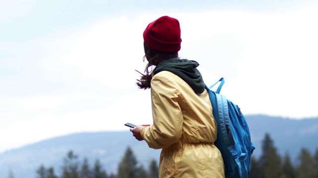 体贴的女人看手机屏幕搜索路线在山区户外。4k女孩旅行者使用手机在农村慢m视频素材