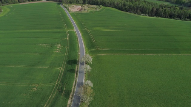 鸟瞰图乡村道路与交通通过景观与农业领域，春天。法兰克尼亚,巴伐利亚,德国。视频素材