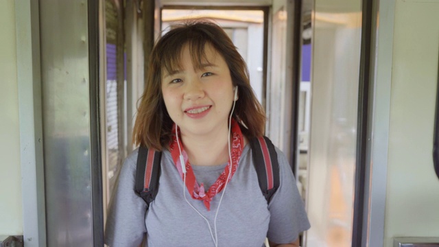 一名亚洲女子在坐火车时边走边找座位，年轻的女性背包客在泰国旅行。少女旅行的生活理念。视频素材