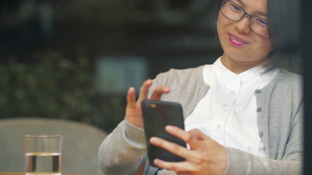 一个年轻的中国女人正在玩手机视频素材