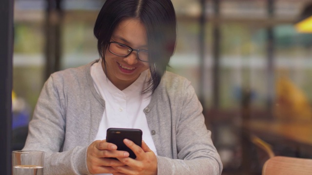 一个年轻的中国女人正在玩手机视频素材