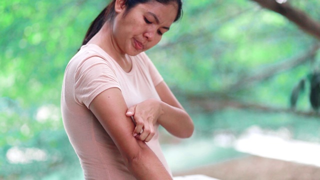 年轻的亚洲女人与痒从叮咬昆虫在手臂，概念与保健和医学视频素材