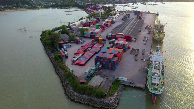 在泰国工业港口的日落货运船上空飞行，有许多集装箱船和大型起重机在工作视频素材