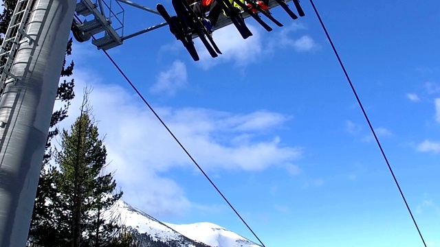 滑雪者和滑雪板者乘坐滑雪缆车，运送到山坡顶部视频素材