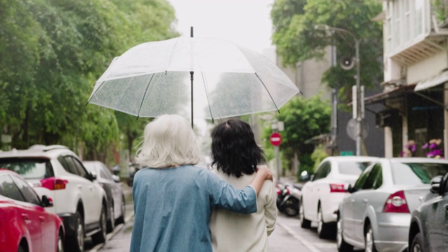 两个老年妇女在一个下雨天在城里散步视频素材