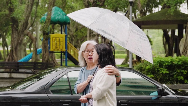 两个老年妇女在一个下雨天在城里散步视频素材