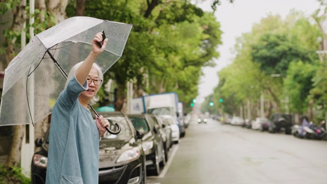 一个雨天，一位老妇人在城市里等出租车视频素材