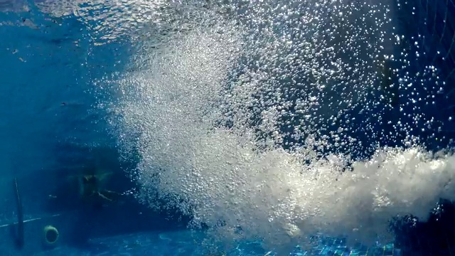 气泡浮在温泉浴池的水面上，背景是正在健康洗澡的人们视频素材