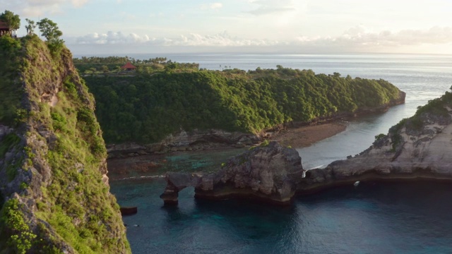 鸟瞰图的绿色热带海岸努沙佩尼达岛，阿图海滩，巴厘岛，印度尼西亚。清澈的蓝色海浪翻滚到海滩。4 k视频素材