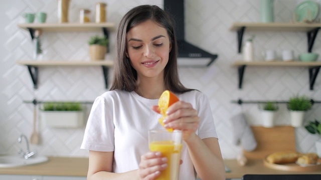 在厨房里做橙汁的女人视频素材