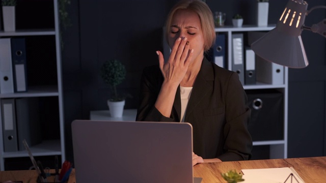 女商人打呵欠，晚上在办公室加班视频素材