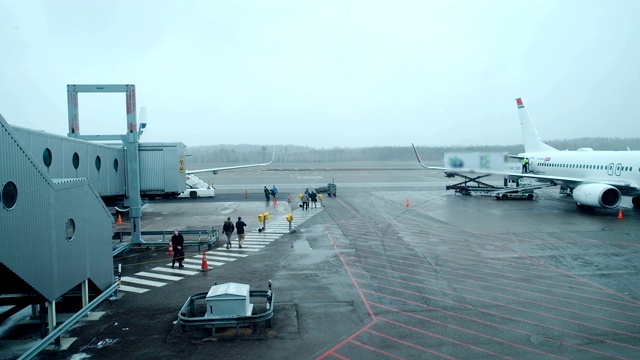 恶劣天气:旅客从机场候机楼走到登机楼梯。在国际机场登机的旅客视频素材