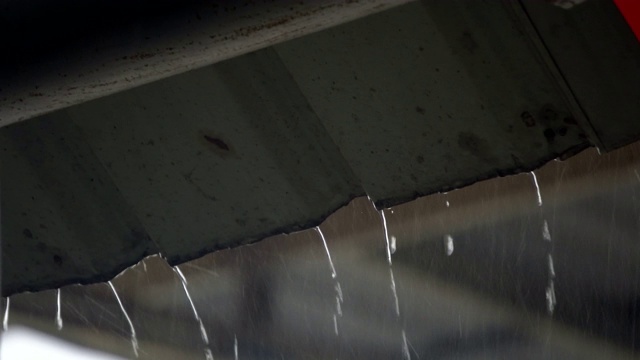 慢镜头:雨滴从屋顶落下视频素材