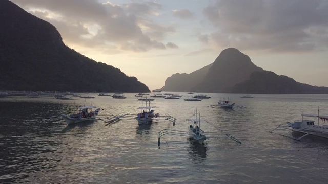 空中近距离观察菲律宾船只在平静的海面在日落视频素材