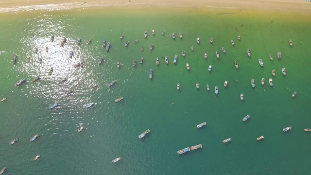 帆船和船只站在蓝色的海洋附近海岸鸟瞰图。渔船和帆船在海港无人机视图视频素材