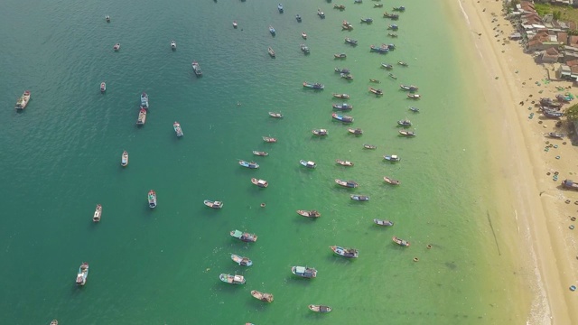 渔船和帆船在蓝色海水附近的沙滩空中景观。海上船只和帆船在停车无人机视图视频素材